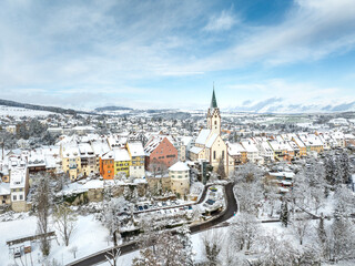 Obraz premium Luftbild von der verschneiten Stadt Engen im Hegau an einem Wintermorgen mit der Kirche Mariä Himmelfahrt in der Altstadt