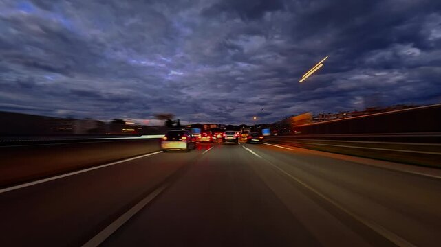 Timelapse of road drive along the highway. Front view to the road and surrounding landscapes. Trees stretch on both sides of road. Fast car hyperlapse. Road trip travel concept sort of dashcam POV