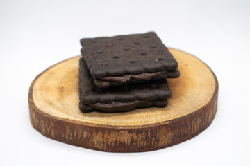 Chocolate biscuits on wood slice with white background