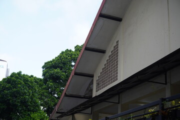 The triangular roof of a building with a roster as a hole for air exchange