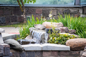 
A fountain in the middle of a stone garden with flowers
