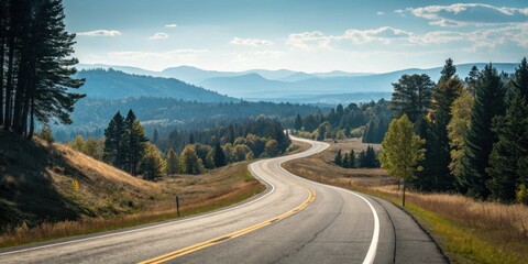 Fototapeta premium A scenic highway winds through a picturesque landscape of rolling hills and dense forests under a bright, sunny sky.
