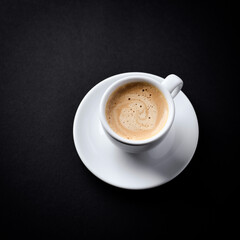 Cup of coffee on dark paper background. Close up. Copy space.	