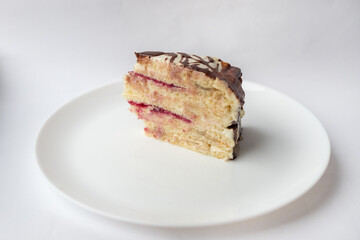 A piece of chocolate pie Milchmadchen with cheese cream sauce with banana and cherry on the white background. Traditional German cake. Ready to eat.