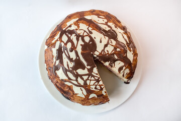 Chocolate pie Milchmadchen with cheese cream sauce with banana and cherry on the white background....