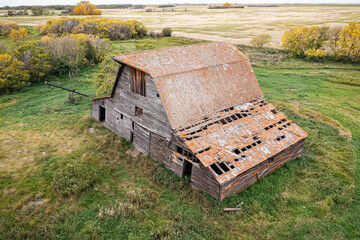 A large, old barn with a lot of rust on it