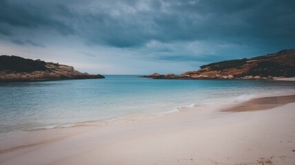Obraz premium Serene beach with soft white sand, calm turquoise water, and a peaceful sky during a tranquil day by the sea.