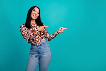 Portrait of nice young girl indicate fingers empty space wear top isolated on turquoise color background