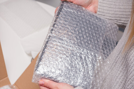 Person is wrapping a package with bubble wrap