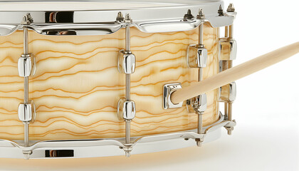 Fototapeta premium Close-up of a snare drum with a beautiful wood grain and chrome hardware; drumstick resting on the drum.