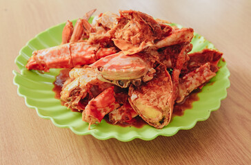 A plate of delicious crabs cooked with sweet and sour sauce in a seafood restaurant.