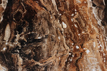 Close-up of marble texture with brown, black, and white veins. Elegant natural pattern perfect for interior design or backgrounds