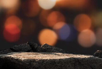 Stone Rock podium on Christmas lights bokeh on black background for product display presentation,Studio Background and Grey Sea Rock Shelf with blurry light and copy space for New Year or Xmas banner