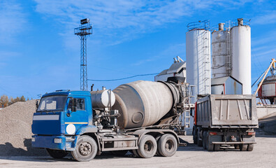 Mixer truck loading concrete on manufacturing plant. Banner cement factory