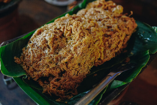 A plate of Indonesian fried omelette named Telur Kribo on top of banana leaf.