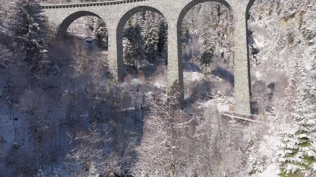 Snowy landscape at Schmitten Albula with Schmittentobel Viaduct in the Swiss Alps on a snowy autumn day. Movie shot November 22nd, 2024, Filisur Albula, Switzerland.