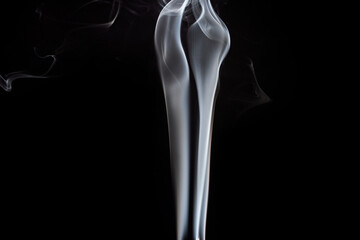 Elegant smoke formations create a mesmerizing visual display against a dark background