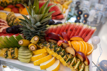 A colorful fruit platter with pineapple, watermelon, oranges, bananas, and other fresh fruits, beautifully arranged for festive occasions. Ideal for events, celebrations, or healthy catering displays.