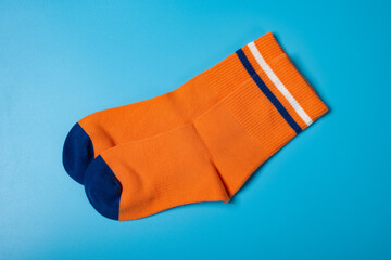 pair of orange socks for boy on blue background