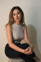 Portrait of a beautiful fashion girl blond in the studio in a nice black trousers