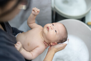 Newborn baby take bath in the bathroom