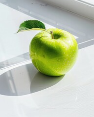 Closeup of a single green apple with a leaf on matte white surface nature food photography indoor setting macro perspective for seo impact