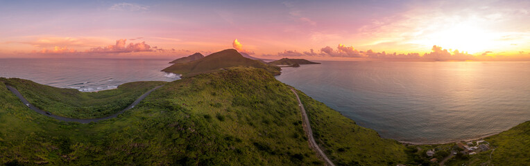 Dramatic sunset over St Kitts, Basseterre, South Friars Bay colorful sun rays painting the clouds pink, red and purple as the sun sets over the Caribbean sea 