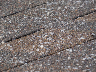 Salt grains on icy sidewalk surface in the winter. Applying salt to keep roads clear and people safe in winter weather from ice or snow