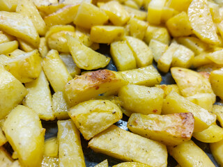 Close-up of potato slices baked in an oven with brown crust