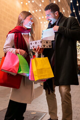 Couple surprised opening gift box festive city night Christmas holiday season