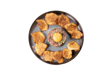 hackepeter meat tartare dish seasoned with raw egg yolk and fried sweet potato chips top view