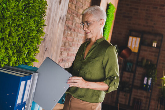 Photo of charming successful lady adminstrator dressed shirt hold folder workplace workstation loft interior indoors