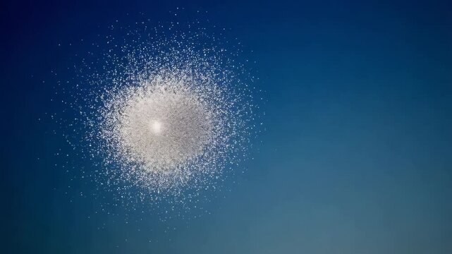 Tiny particles gracefully gather and then explode outward in a soft yet captivating manner