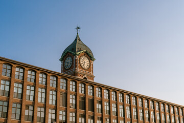 Iconic Ayer Mill clock tower and nineteenth century brick mill building in the historic immigrant city of Lawrence Massachusetts.