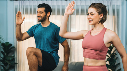 Athletic and sporty fitness couple or exercise buddy running posture at home body workout exercise session for fit physique and healthy sport lifestyle at home. Gaiety home exercise workout training.