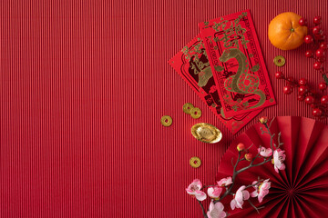 Festive Chinese New Year setup featuring red envelopes, gold coins, a tangerine, and traditional...