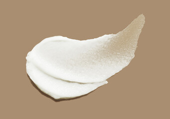 Cosmetic swatch of white exfoliator scrub or gel balm with micro capsules, sugar or salt isolated on cofee brown background