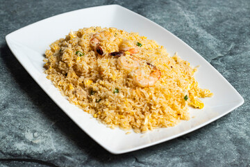 Mixed fried Rice with shrimp, prawn, egg and chicken served in tray dish isolated on grey background side view of thai food