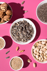 Semillas de chía, sésamo, nueces y pistachos. Frutos secos sobre un fondo rosa. Vista superior