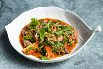 Beef Salad including tomato, onion, coriander and gravy served in bowl isolated on grey background side view of thai food