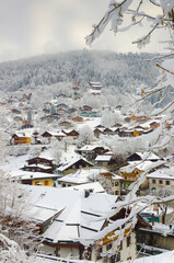 Winter scene of village Morzine in French Alps with alpine houses and ski resort.