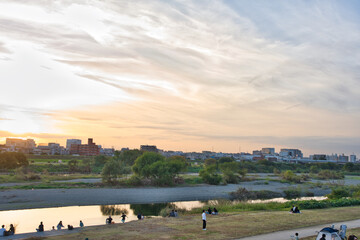 夕暮れの河川敷で遊ぶ子供たち
