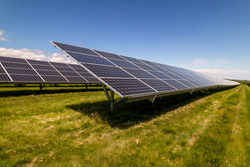 Solar farm close up view, field of solar power plant with photovoltaic cells in panel at sunny summer day. Green technology landscape and clean electricity generation from sun. Carbon footprint reduce