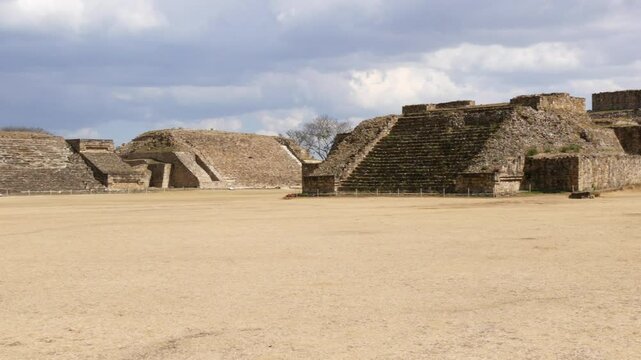 Ancient Mayan Plaza and Temple Ruins Under Cloudy Mexican Sky at Monte Alban