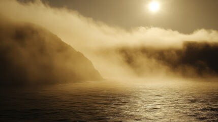 Misty coastal scene at sunset, sunlit ocean, shrouded cliffs.