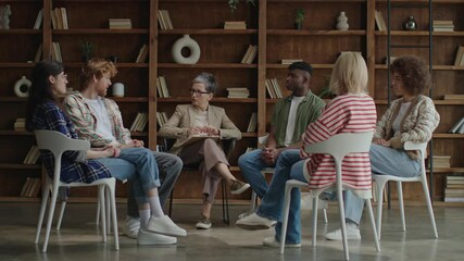 In a contemporary setting, six diverse young adults convene in a circle for a therapeutic session, fostering growth and solidarity