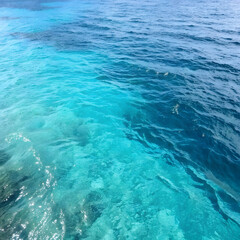 Obraz premium image captures stunning view of clear turquoise water, showcasing vibrant colors and textures of ocean surface. interplay of light creates mesmerizing effect, inviting sense of tranquility and