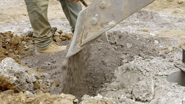 Construction site activity shows excavation and filling with gravel at a development location