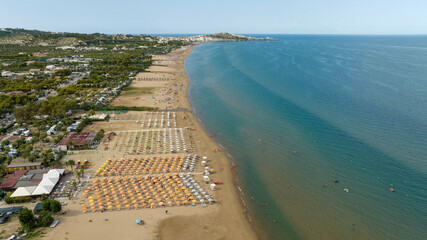 Aerial view of the long beach of Vieste, a tourist destination of Gargano, in the province of Foggia, Puglia, Italy. In the background is the historic center of the city.
