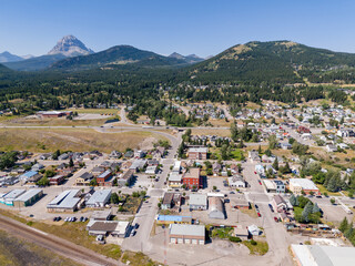 Aerial old coal mining town overlooking distant landmark mountains along the Crowsnest Pass in Southern Alberta.